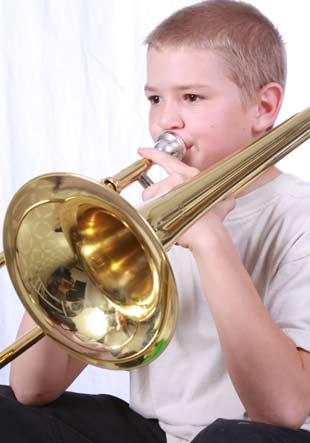 Kid with brass trumpet playing fun music in school